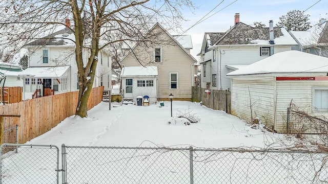 snow covered property featuring fence and a residential view