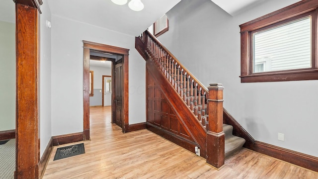 staircase featuring baseboards, visible vents, and wood finished floors