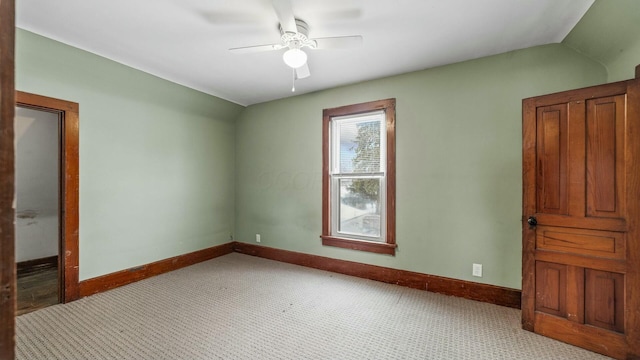 unfurnished room featuring lofted ceiling, carpet flooring, a ceiling fan, and baseboards