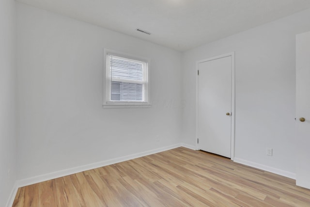 unfurnished room featuring light wood finished floors, baseboards, and visible vents