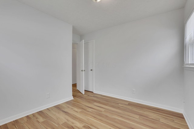 empty room with light wood-style flooring and baseboards