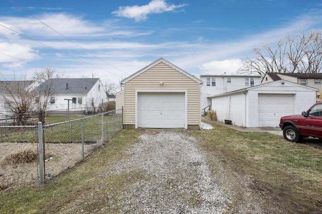 detached garage with driveway and fence