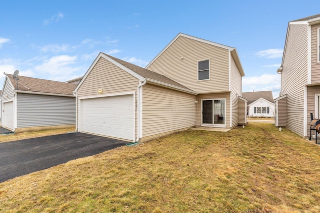 exterior space with a front lawn, an attached garage, and aphalt driveway