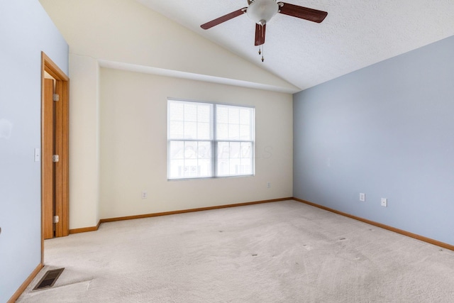 spare room with lofted ceiling, carpet flooring, visible vents, and baseboards