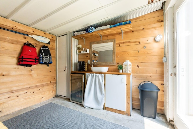 interior space with concrete flooring, wood walls, and a sink