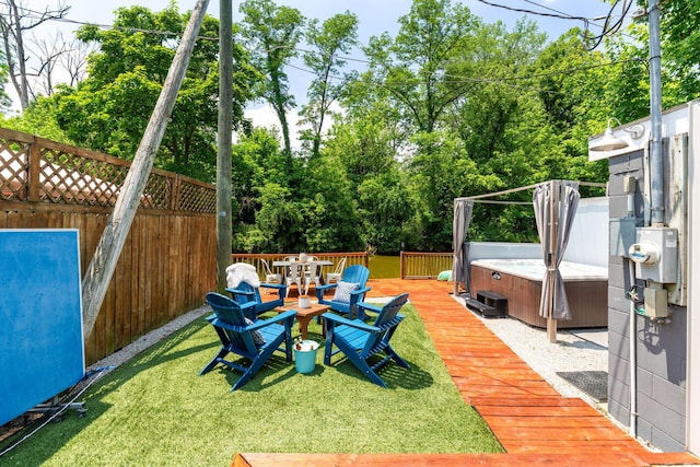 view of yard featuring a hot tub, fence, and a wooden deck