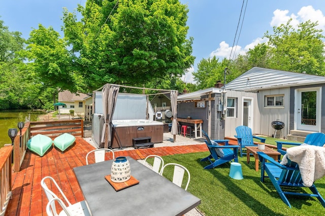 exterior space featuring a hot tub, area for grilling, a lawn, and outdoor dining space