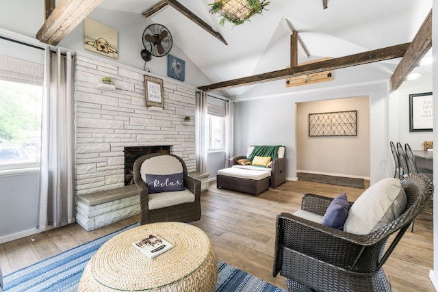 living room with lofted ceiling with beams, a fireplace, hardwood / wood-style flooring, and baseboards