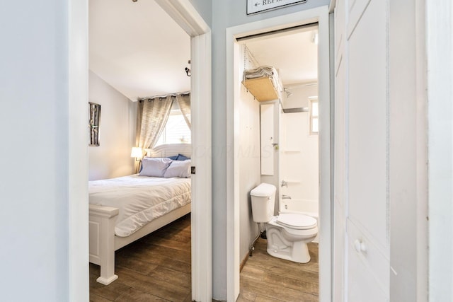 bedroom with connected bathroom and wood finished floors