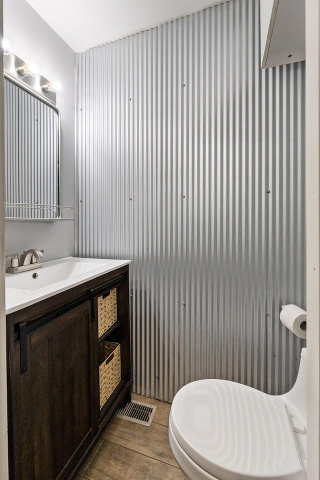 bathroom with visible vents, wood finished floors, and vanity