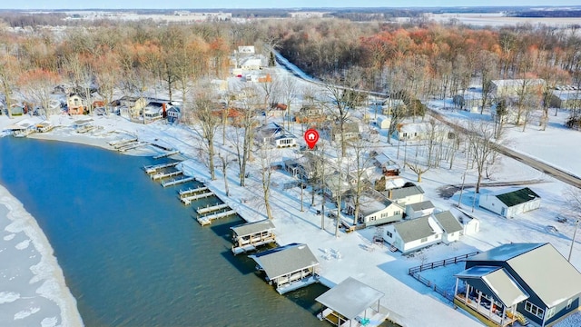 snowy aerial view with a water view and a residential view