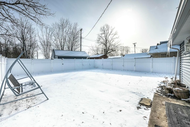 yard layered in snow featuring a fenced backyard