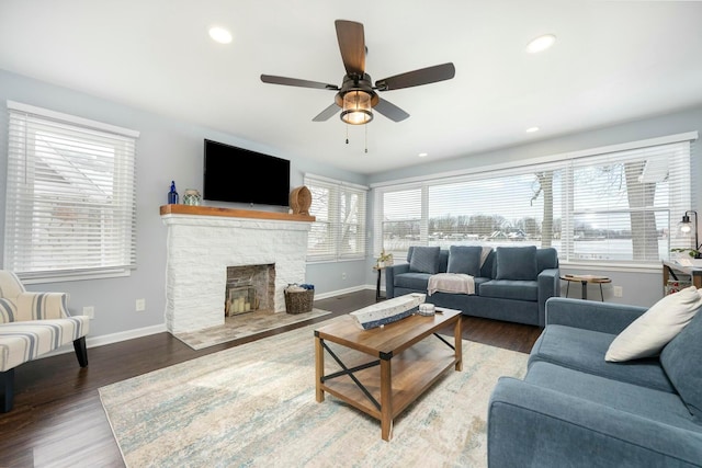 living room with recessed lighting, a fireplace, wood finished floors, a ceiling fan, and baseboards