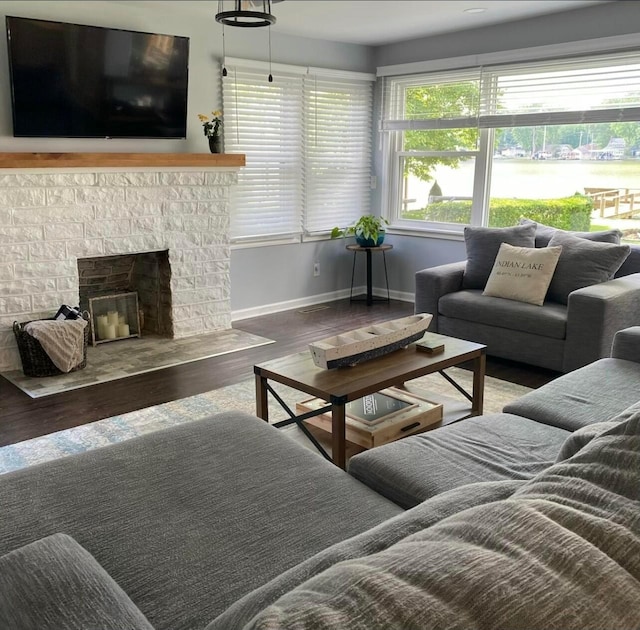 living area with a fireplace, baseboards, and wood finished floors