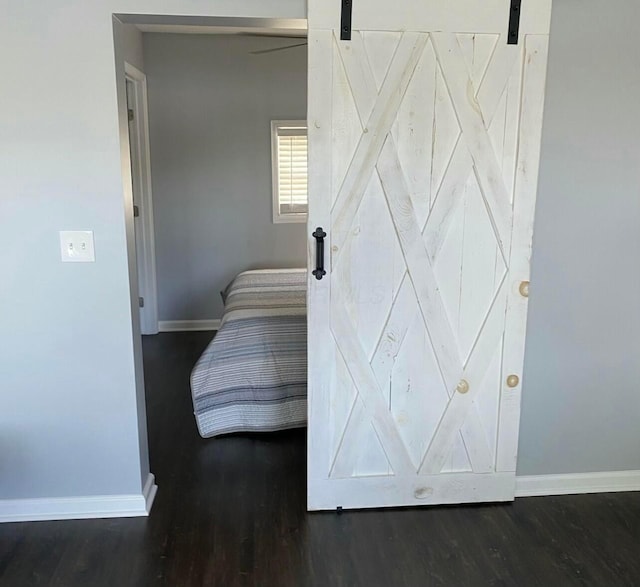 bedroom featuring a barn door and baseboards