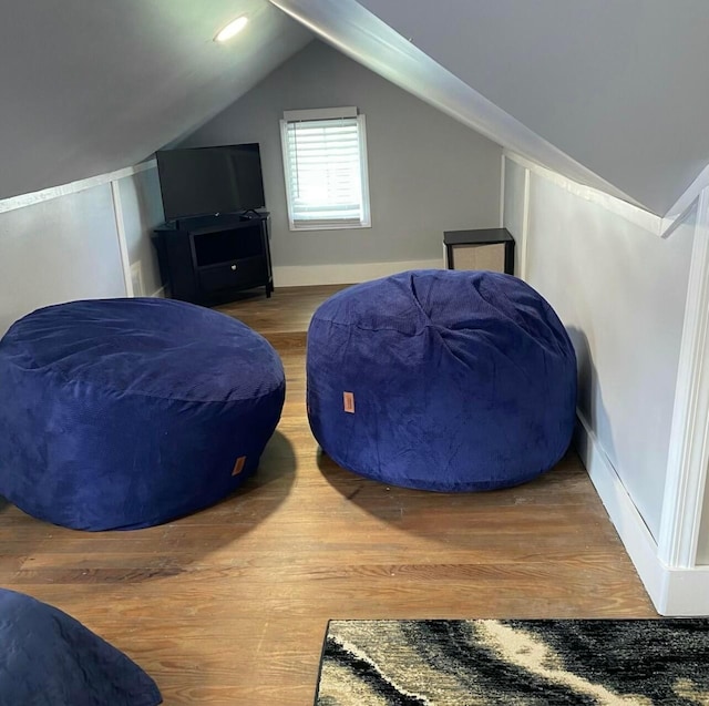 bedroom featuring lofted ceiling, baseboards, and wood finished floors