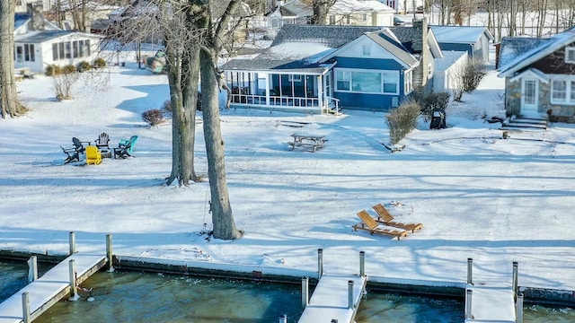 snowy yard with a dock and a sunroom