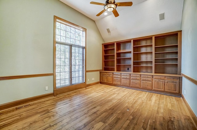 spare room featuring lofted ceiling, baseboards, visible vents, and light wood-style floors