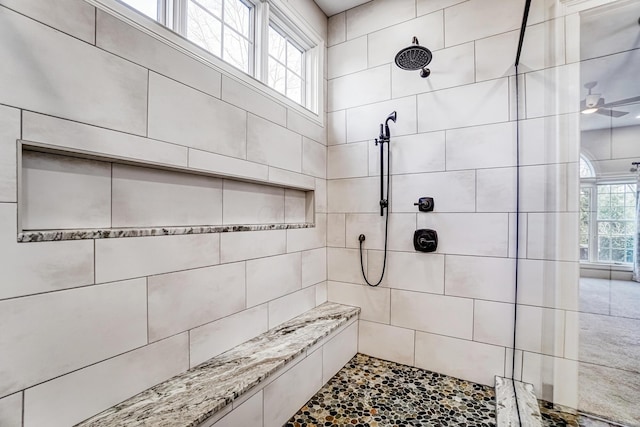 full bathroom featuring plenty of natural light, ceiling fan, and tiled shower