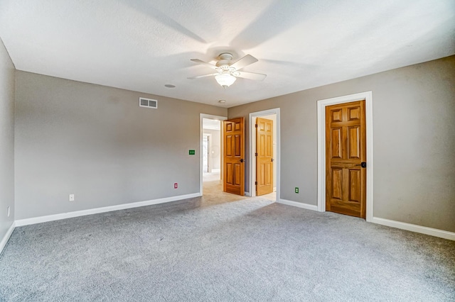 unfurnished room featuring light colored carpet, visible vents, ceiling fan, and baseboards