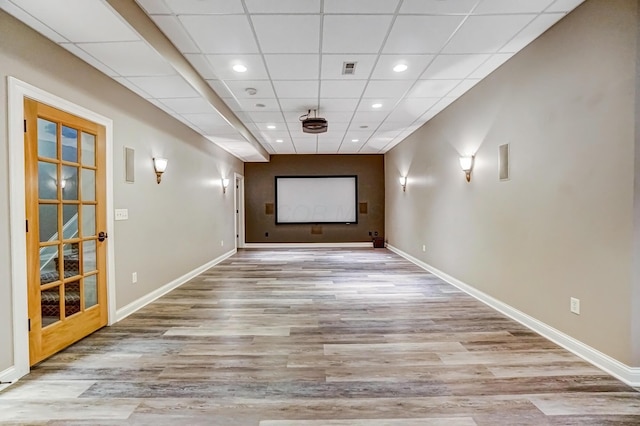 cinema featuring a paneled ceiling, recessed lighting, light wood-style flooring, and baseboards