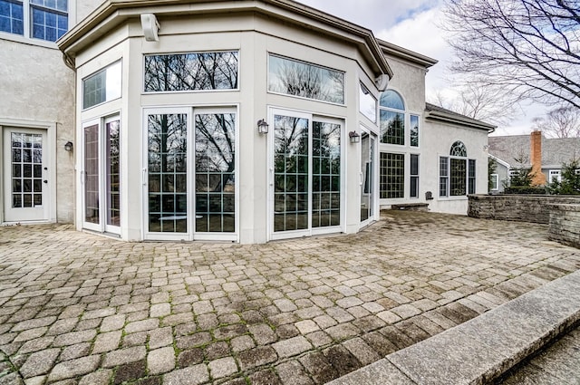 doorway to property featuring a patio area and stucco siding