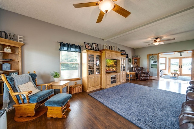 living area with dark wood-style floors, french doors, a textured ceiling, and a ceiling fan