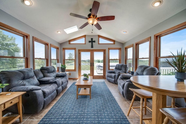 living area featuring ceiling fan, light tile patterned floors, recessed lighting, french doors, and lofted ceiling with skylight