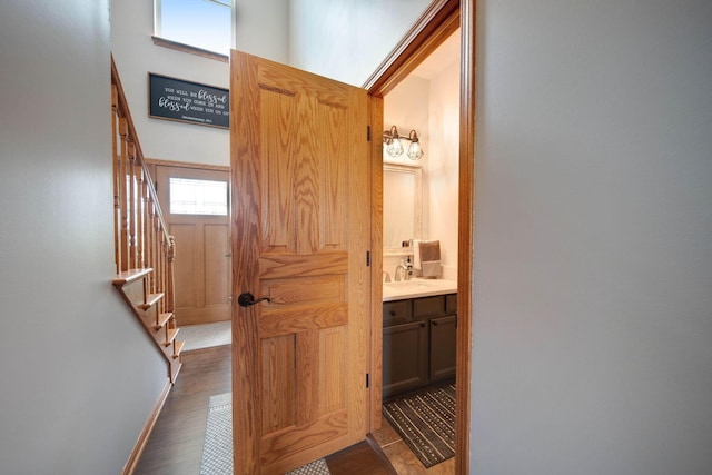 corridor featuring stairs, dark wood finished floors, and baseboards