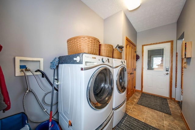 clothes washing area with laundry area, baseboards, a textured ceiling, and washing machine and clothes dryer