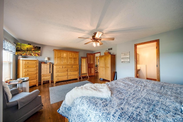 bedroom featuring dark wood-style floors, a ceiling fan, visible vents, and a textured ceiling