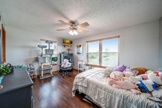 bedroom featuring dark wood-type flooring, ceiling fan, a textured ceiling, and baseboards