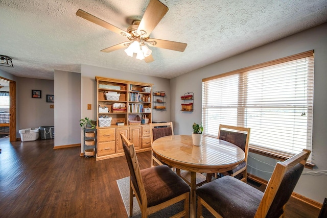 dining room featuring dark wood-style floors, ceiling fan, a textured ceiling, and baseboards