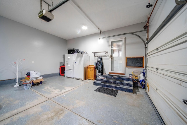 garage featuring white refrigerator with ice dispenser and a garage door opener