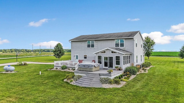 rear view of property with a yard, a patio, and a hot tub