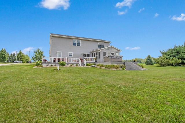 back of house featuring a lawn and a wooden deck