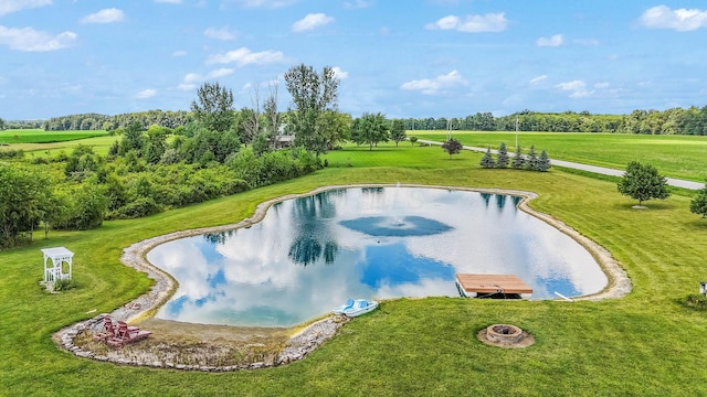 view of swimming pool featuring a water view, a yard, and a rural view