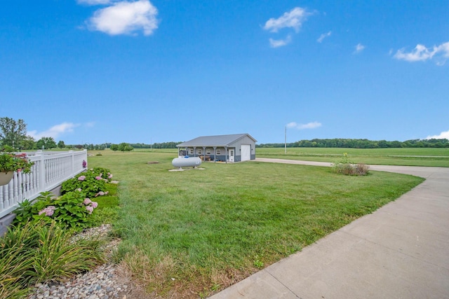 view of yard with a garage and a rural view