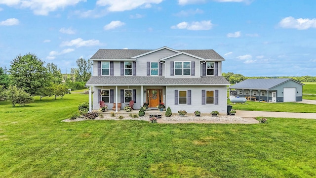 view of front of home featuring a detached garage, a porch, and a front yard