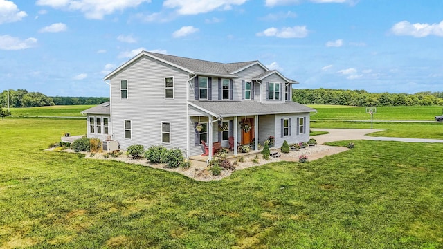 view of front of property with covered porch, a shingled roof, and a front lawn