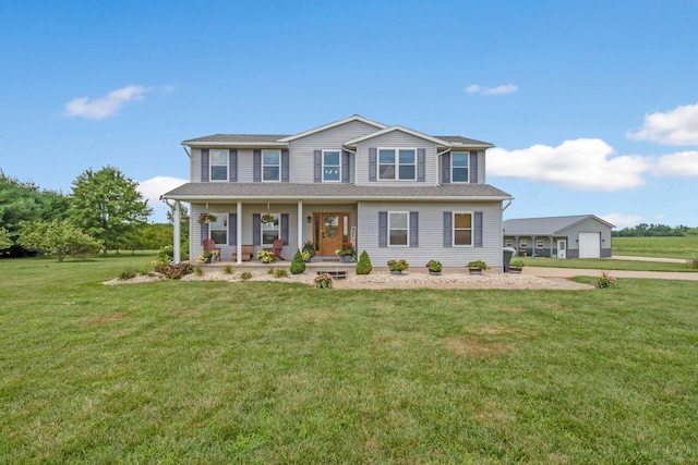 view of front of home featuring a porch, a detached garage, and a front lawn