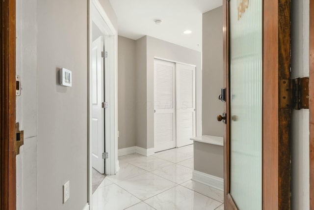 hallway with marble finish floor and baseboards