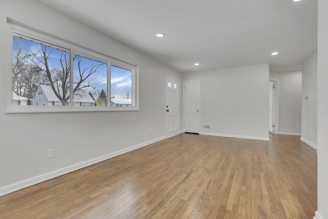 empty room with light wood-type flooring, baseboards, and recessed lighting