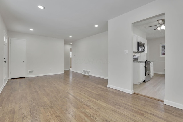 empty room featuring light wood finished floors, visible vents, and recessed lighting