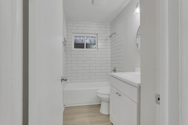 bathroom with toilet, shower / bathtub combination, wood finished floors, and vanity