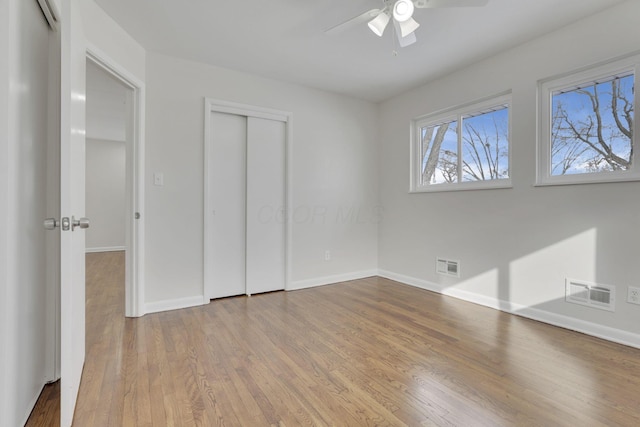 unfurnished bedroom featuring light wood-type flooring, visible vents, and a closet