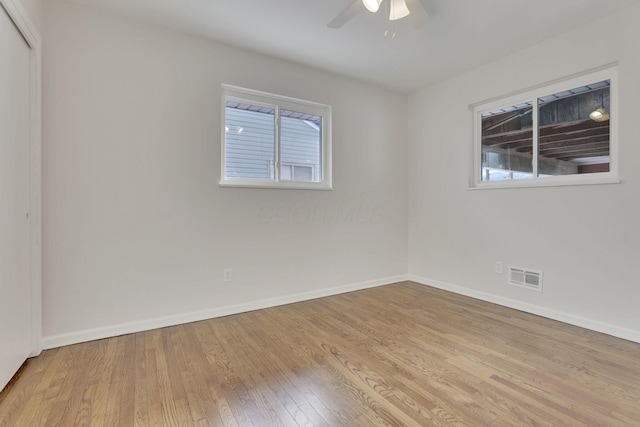 empty room featuring ceiling fan, light wood-type flooring, visible vents, and baseboards