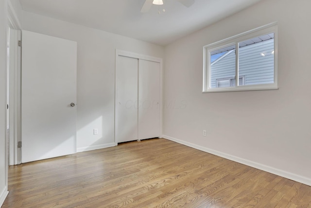 unfurnished bedroom with a closet, light wood-style flooring, and baseboards