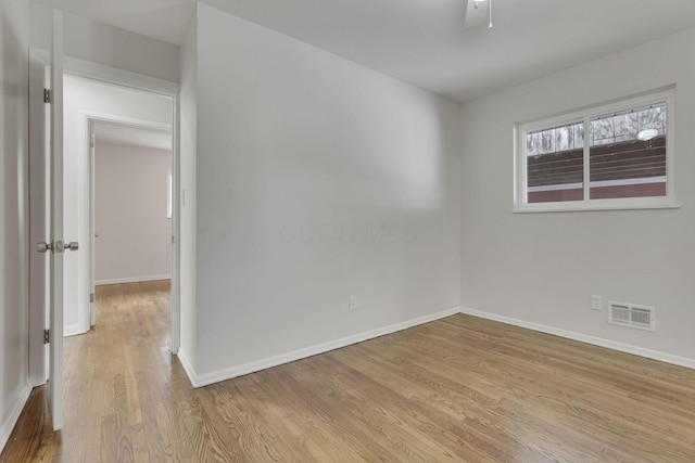 unfurnished room featuring baseboards, visible vents, and light wood finished floors