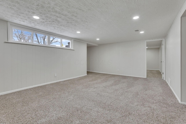 basement featuring carpet floors, a textured ceiling, and recessed lighting